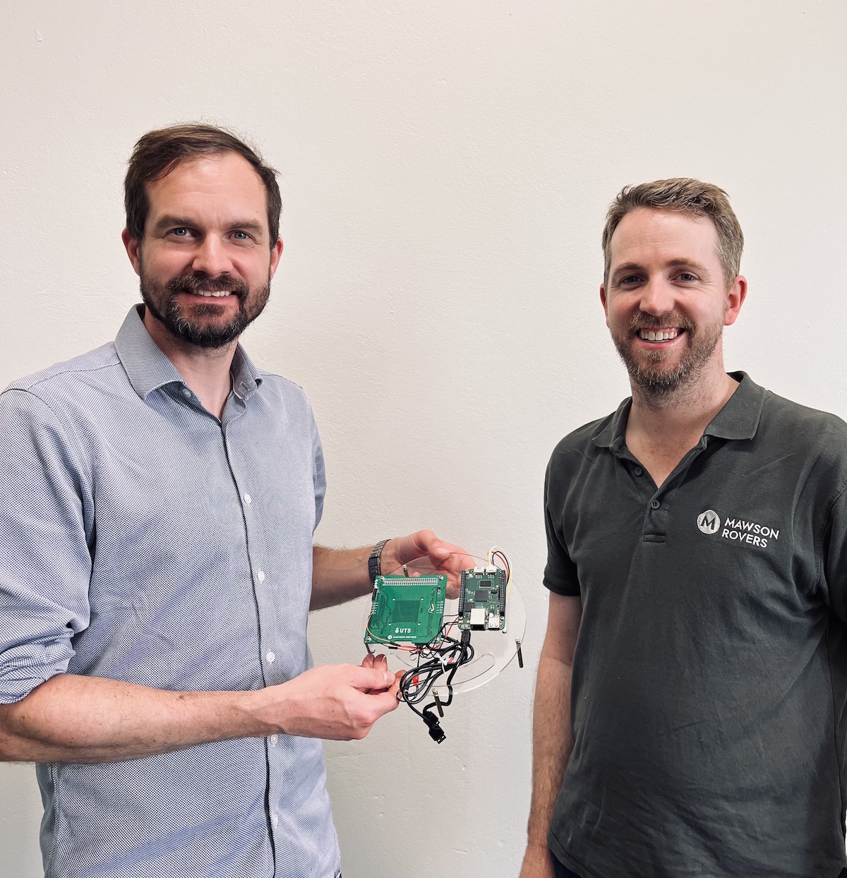 Photo of Nick Bennett and Matt Ryall with Mawson Rovers payload
            hardware for UTS